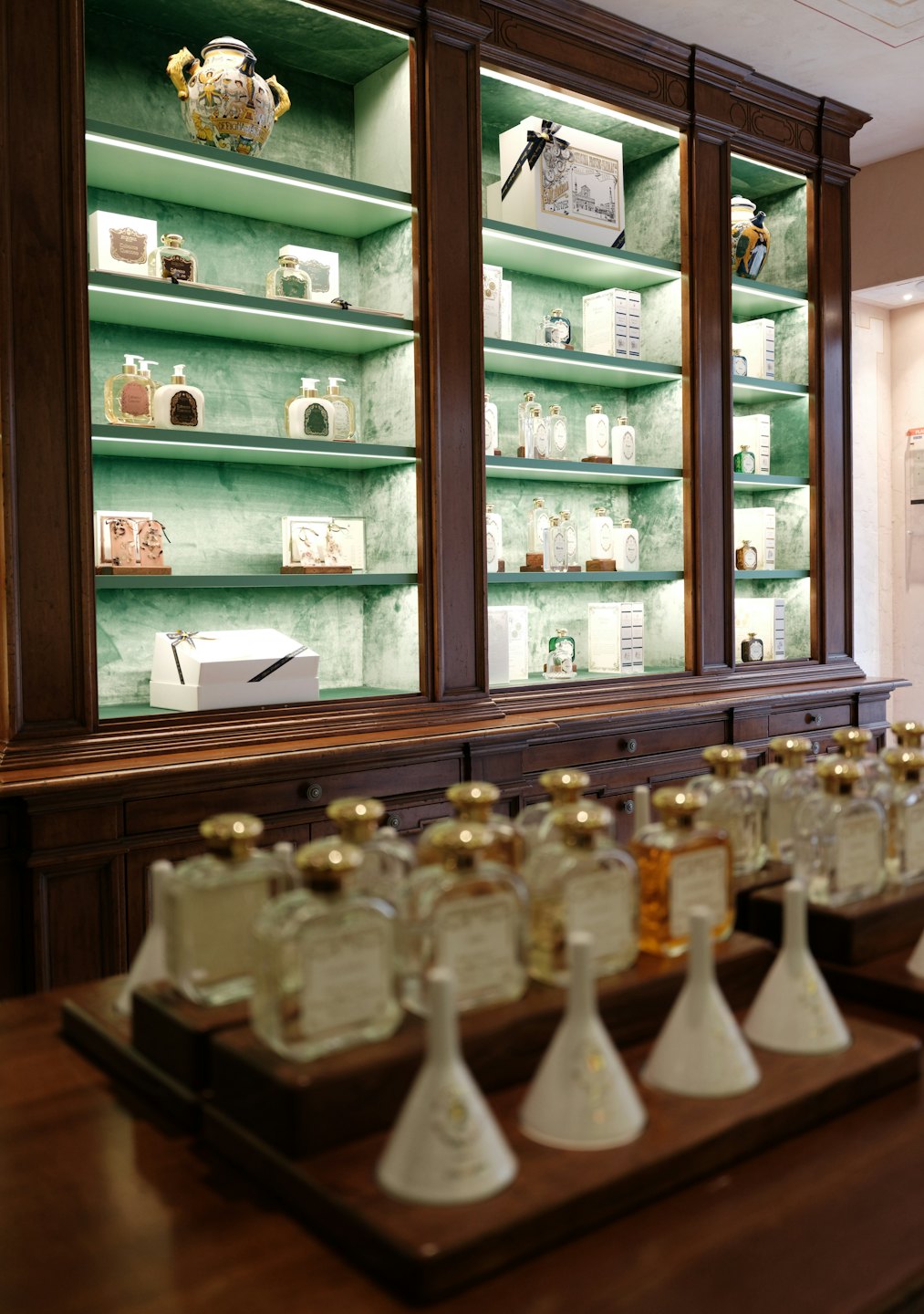 Luxuriöse Parfums und Kosmetika, die in Samt ausgekleideten Regalen ausgestellt sind.